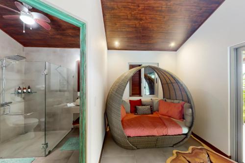 a bathroom with a wicker chair with a mirror at Terrazas de Ballena in Uvita