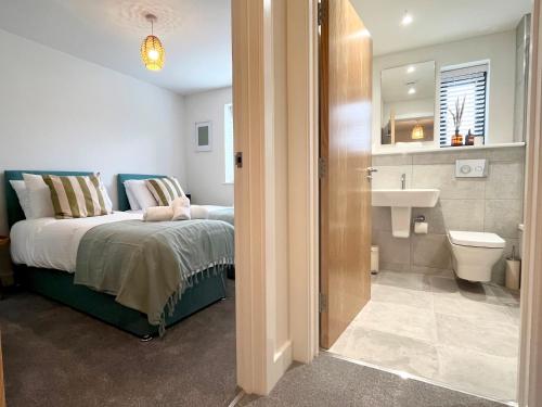 a bedroom with a bed and a bathroom with a sink at Exceptional 3 bedroom home in Penzance~New~Seaside in Penzance