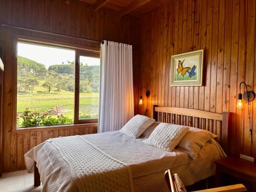sypialnia z łóżkiem i dużym oknem w obiekcie Pousada Rural Vista Alegre w mieście Bom Jardim da Serra