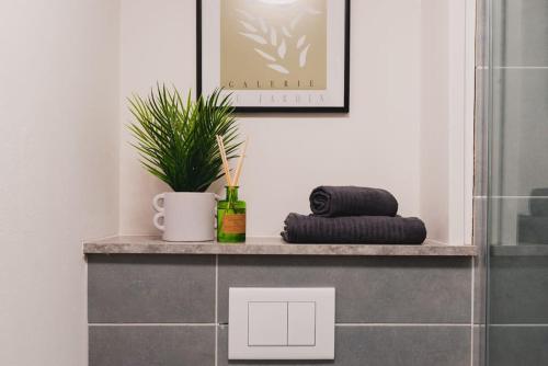 a bathroom with a shelf with a plant and a towel at Stunning Brand New One Bed City Apartment in Leicester