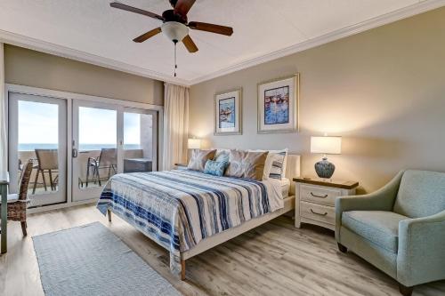a bedroom with a bed and a chair and a window at 291 Sandcastles in Amelia Island