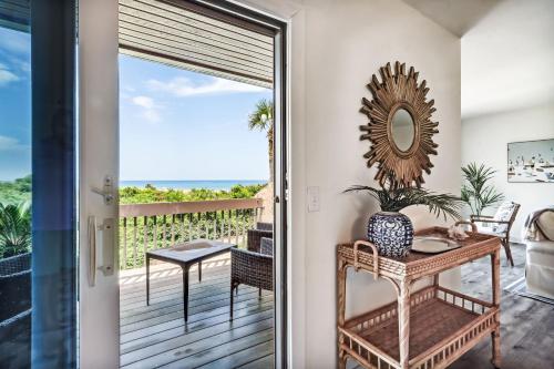 a room with a balcony with a table and a mirror at 1401 Windsong in Amelia Island