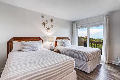 two beds in a room with a window at 1401 Windsong in Amelia Island