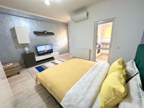 a bedroom with a bed and a flat screen tv at Nice apartment in Militari Residence in Roşu