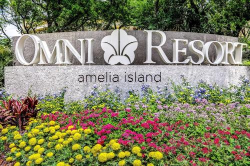 a sign for the om resort andalo island with flowers at 3050 Club Villas in Amelia Island