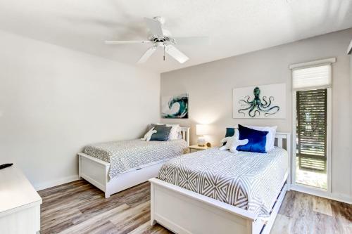 a bedroom with two beds and a ceiling fan at 3050 Club Villas in Amelia Island