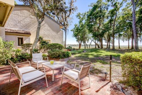 a patio with a table and chairs and trees at 3050 Club Villas in Amelia Island