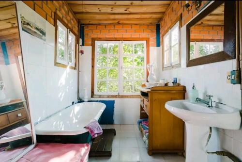 baño con bañera, lavabo y ventana en Pousada Villa Morena en Florianópolis