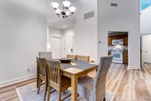 a dining room and kitchen with a wooden table and chairs at 2349 Courtside Villas in Amelia Island