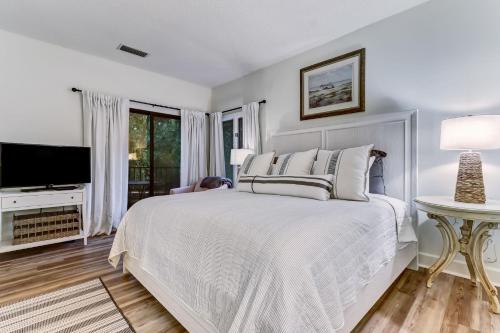 a white bedroom with a bed and a television at 2349 Courtside Villas in Amelia Island