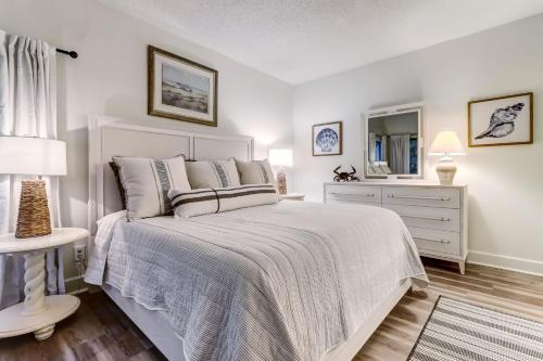 a bedroom with a bed and a dresser and a mirror at 2349 Courtside Villas in Amelia Island