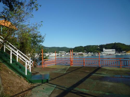 a bridge with a red railing next to a body of water at Seaside Hostel Light House - Vacation STAY 82336v in Onomichi