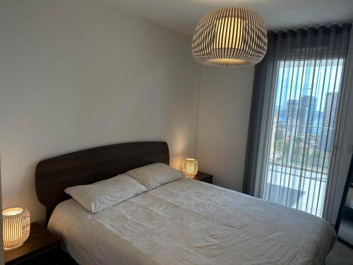1 dormitorio con cama y ventana grande en Magnifique 3 pièces avec vue mer, en Beausoleil