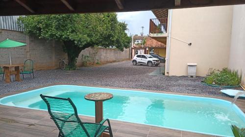 a swimming pool with chairs and a table and a car at Pousada Segredo in Bonito