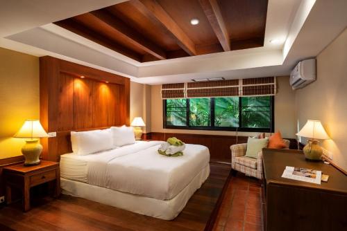 奈漢海灘的住宿－The Sands 2 bedroom apartment Naiharn，卧室设有一张白色大床和一扇窗户。