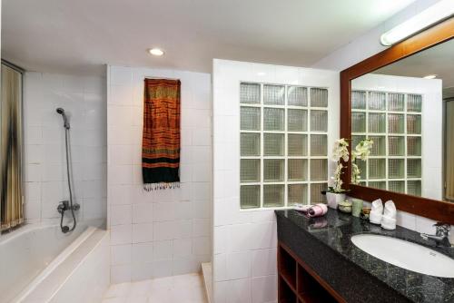 bagno con vasca, lavandino e specchio di The Sands 2 bedroom apartment Naiharn a Nai Harn Beach