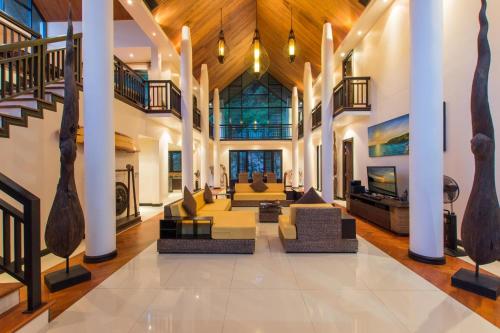 a living room with couches and tables in a building at Hidden Pool Villa A Hidden Haven Just For You in Rawai Beach