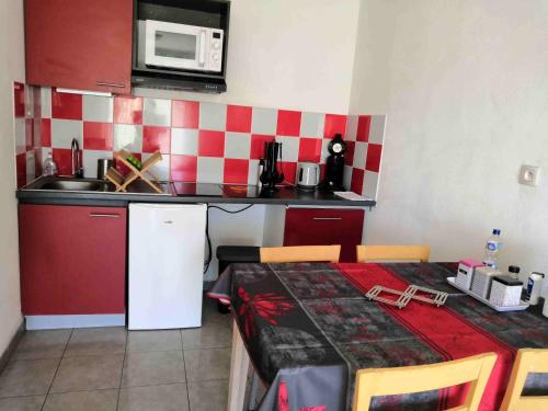 a small kitchen with a table and a microwave at Appartement T2 - Golf de Fontcaude - Résidence Coté Green à Juvignac 34990 in Juvignac