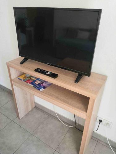 a flat screen tv sitting on a wooden stand at Appartement T2 - Golf de Fontcaude - Résidence Coté Green à Juvignac 34990 in Juvignac