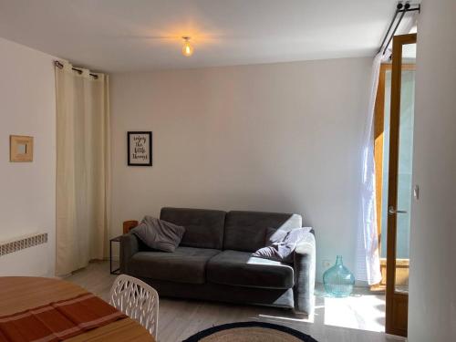 a living room with a couch and a window at Accueillant petit T2 cœur de centre ville in Lézignan-Corbières