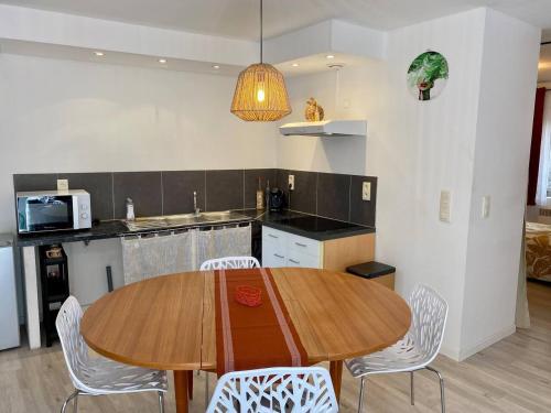 a kitchen with a wooden table and chairs at Accueillant petit T2 cœur de centre ville in Lézignan-Corbières