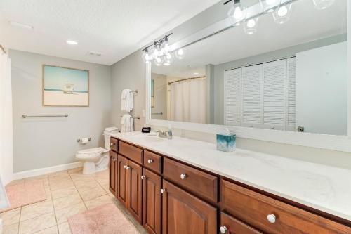 a bathroom with a sink and a toilet and a mirror at 1817 Turtle Dunes in Amelia Island