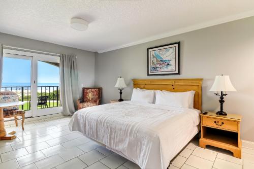 a bedroom with a large bed and a balcony at 1817 Turtle Dunes in Amelia Island