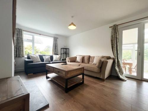 a living room with a couch and a coffee table at Bright Bungalow with 3 bedrooms and Garden in Porthlevan in Porthleven