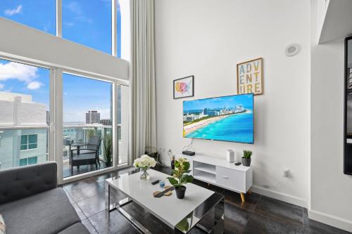 a living room with a tv and a large window at Amazing Loft Style 1 Bedroom In Brickell Miami in Miami
