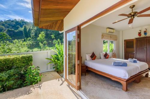 Un dormitorio con una cama y una ventana grande. en Aster Pool Villa, en Rawai Beach