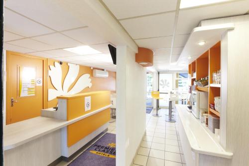 a hospital hallway with a waiting room with yellow walls at Premiere Classe Beziers in Béziers