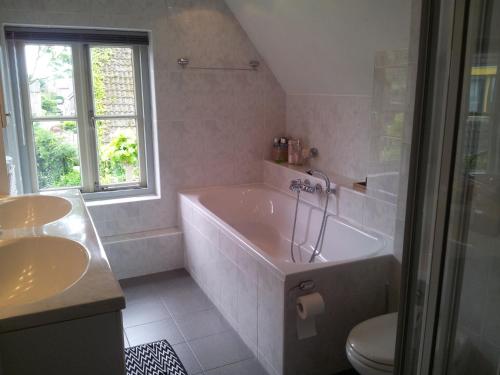 ein Badezimmer mit einer Badewanne, einem Waschbecken und einem WC in der Unterkunft Bed and Breakfast Millingen aan de Rijn in Millingen am Rhein