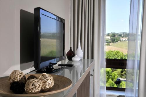a living room with a tv and a table with a table at Hotel Federico II in Iesi