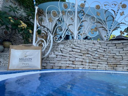 a shopping bag sitting next to a swimming pool at Milton Boutique Hotel - Adults Only in Lido di Jesolo