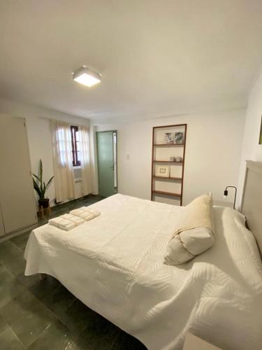 1 dormitorio con 1 cama blanca grande con almohadas en Acogedor departamento céntrico en PB en Posadas