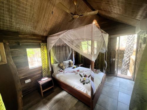 a bedroom with a bed with a mosquito net at AbCa's Creek Lodge in Bintang