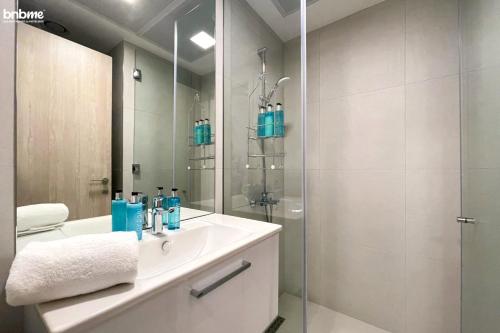 a bathroom with a sink and a glass shower at bnbmehomes - Modern Luxury Studio in heart of JVC - 419 in Dubai