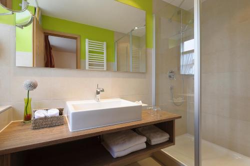ein Badezimmer mit einem weißen Waschbecken und einer Dusche in der Unterkunft Landgasthof zum Adler in Lippertsreute