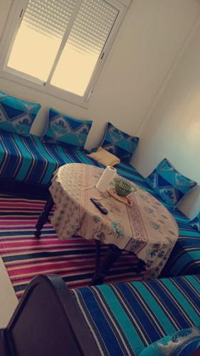 una camera da letto con un tavolo e un ombrello su un letto di STUDIO OUSSAMA a Bouskoura