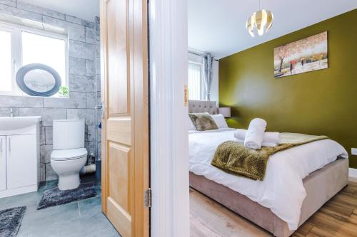 Stylish 3 Bedroom home close to Manchester City centre في أولدهام: غرفة نوم بسرير وحمام مع مرحاض