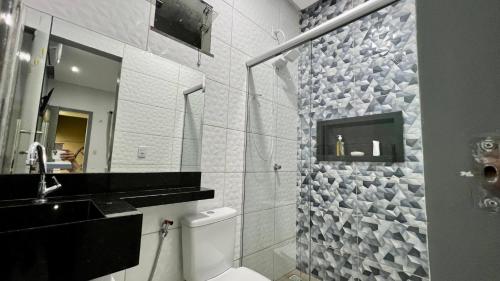a bathroom with a toilet and a sink and a mirror at Casa Exclusive Salinas Atalaia in Salinópolis