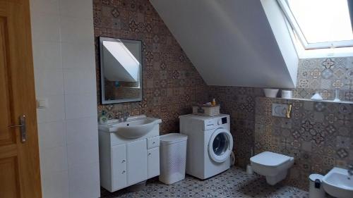a bathroom with a sink and a washing machine at U Janciów in Krakow