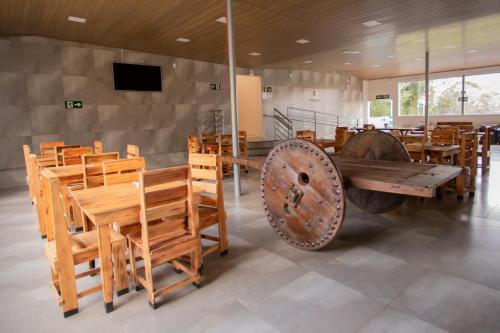 a room with wooden tables and chairs and a wheel at Ribeiro Suit's Hotel in Araxá