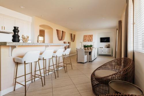 a kitchen with a bar with white stools at Luxe Boho Retreat Near Torrey Pines - Sleeps 10 in San Diego