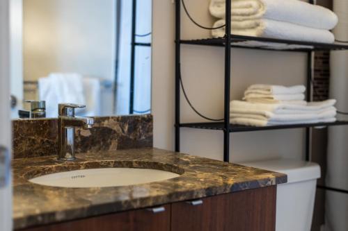 a bathroom with a sink and a shelf with towels at Ultra Luxurious 2.5 Bedroom 2 Full Bathroom 1 Parking Condo Near SQ1 Striking Views in Mississauga