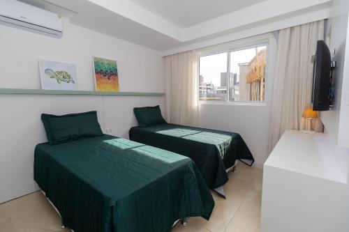 Cette chambre comprend 2 lits et une fenêtre. dans l'établissement Terrazzo 602B - Cobertura duplex à poucos metros da praia de Bombas - Condomínio com piscina - Academia - Solário, à Bombinhas