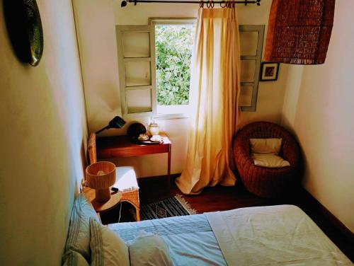 シェフシャウエンにあるDar SBAAのベッドルーム1室(ベッド1台、窓、椅子付)