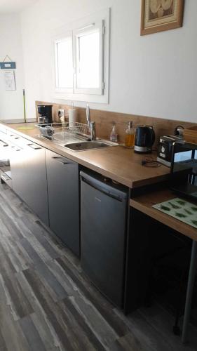 une cuisine avec un évier et un plan de travail en bois dans l'établissement Mon gîte à Pélasque, à Lantosque