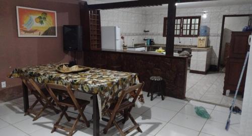 una cocina con mesa y algunas sillas y una cocina con encimera. en Casa Buzios moreira campos, en Búzios