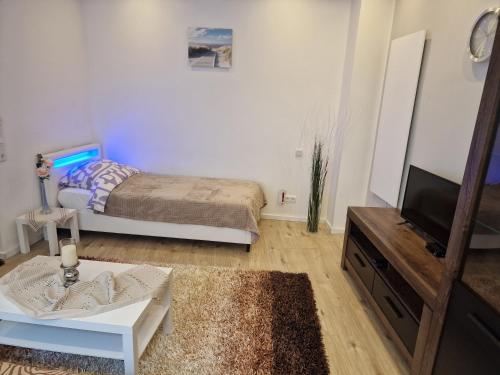 ein kleines Schlafzimmer mit einem Bett und einem TV in der Unterkunft Apartment Wuppertal Heckinghausen in Wuppertal